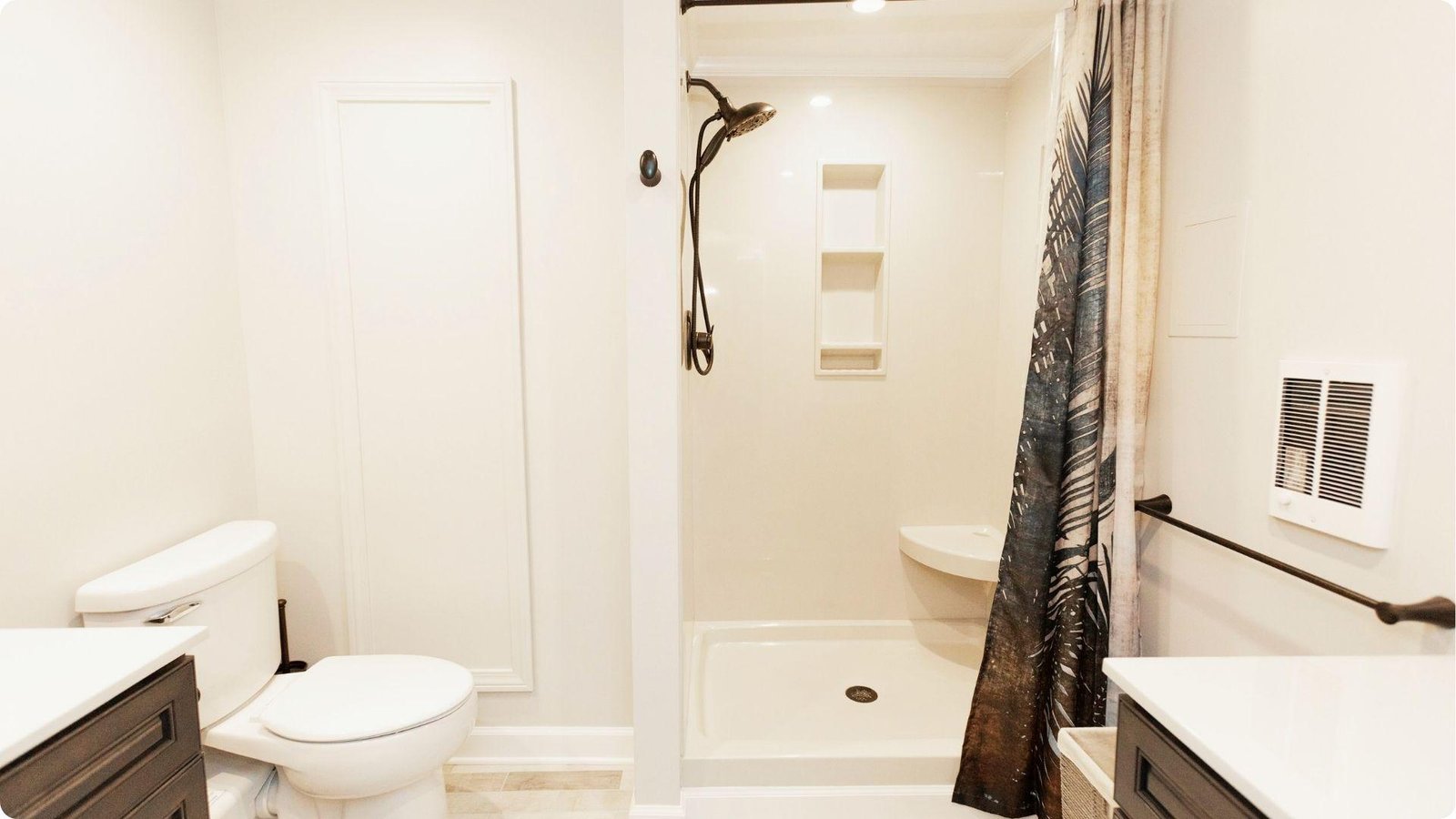 Clean basement bathroom with toilet, shower stall with curtain, and dark wood vanity.