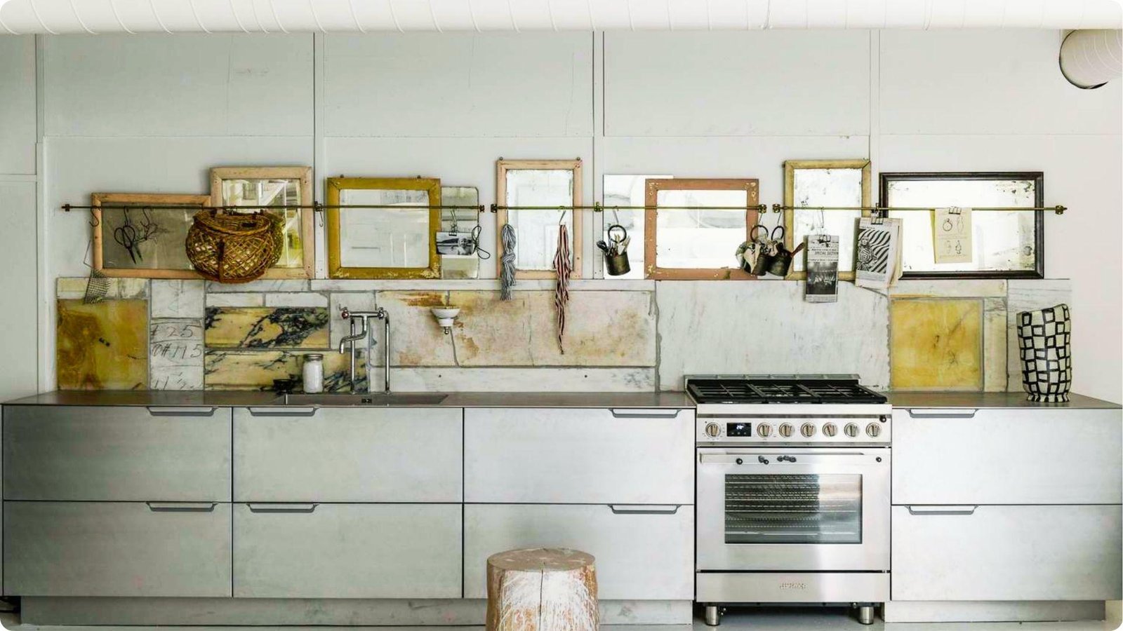 Industrial-style kitchenette with matte steel cabinets, concrete countertop, and gas range.