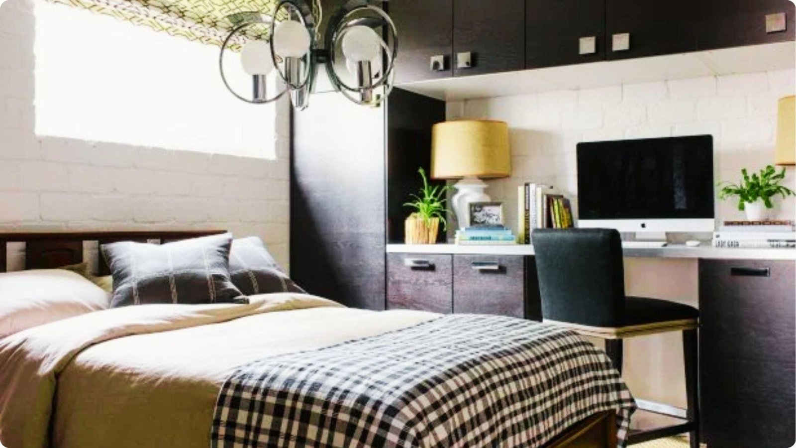 Multi-functional basement guest suite featuring a bed with plaid bedding next to a built-in desk and storage.