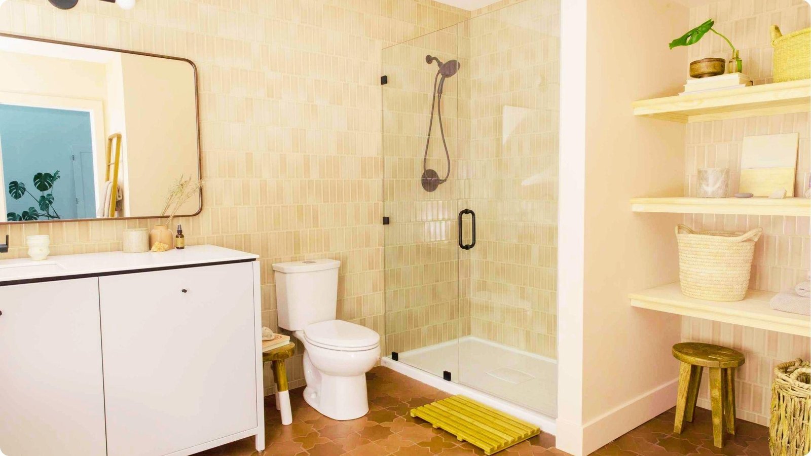 Bright basement bathroom with beige vertical tile, white vanity, and glass shower.