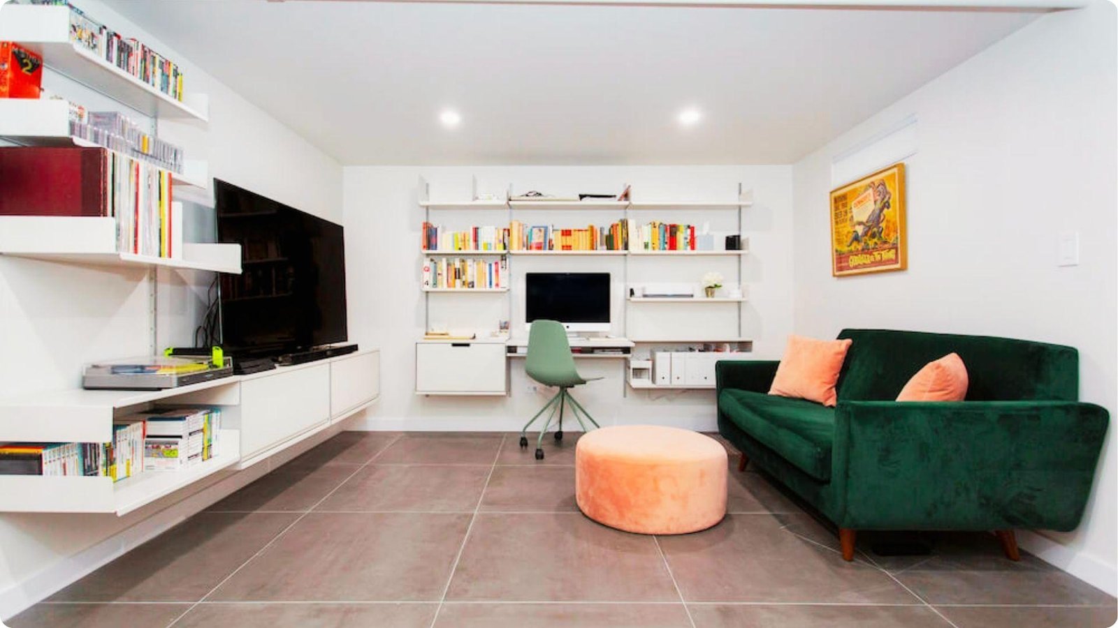 Modern basement media and office combo with floating white shelving and tile floors.