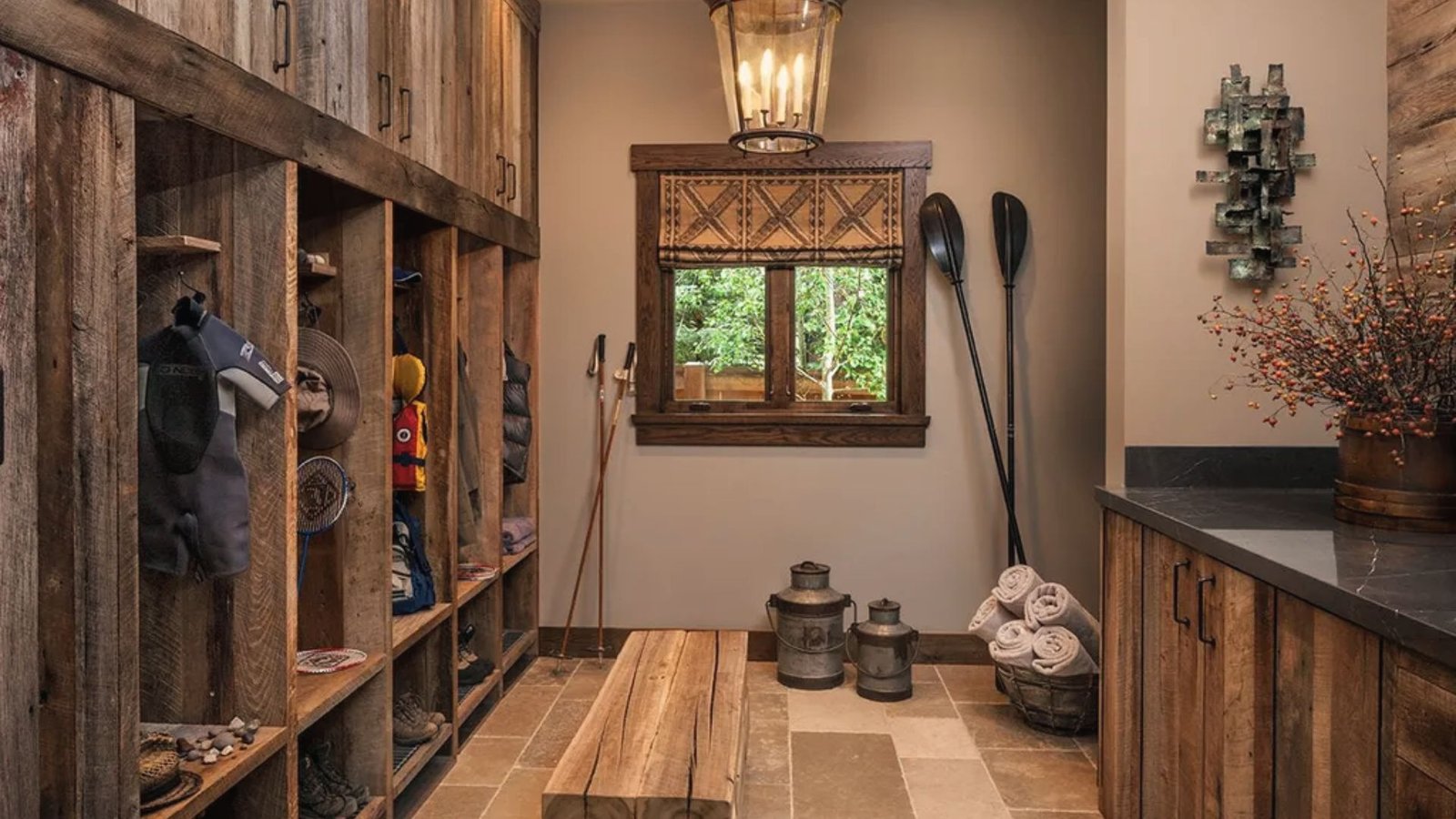 Rustic basement mudroom with reclaimed wood lockers, bench, window and gear for outdoor activities.