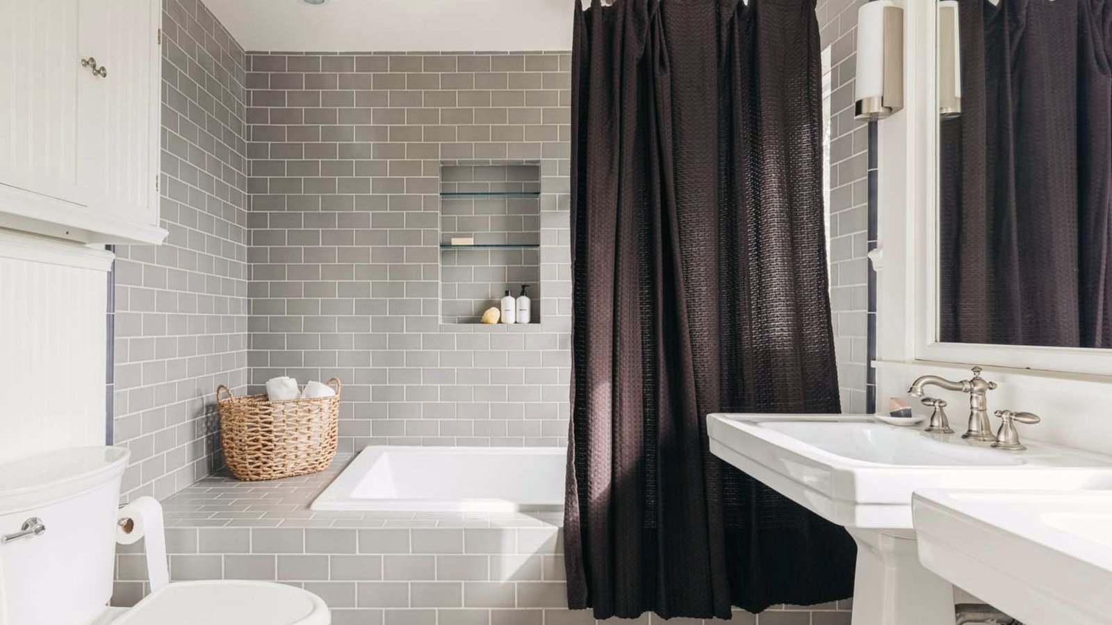 Gray tile bathroom with dark curtain tub deck with side access.