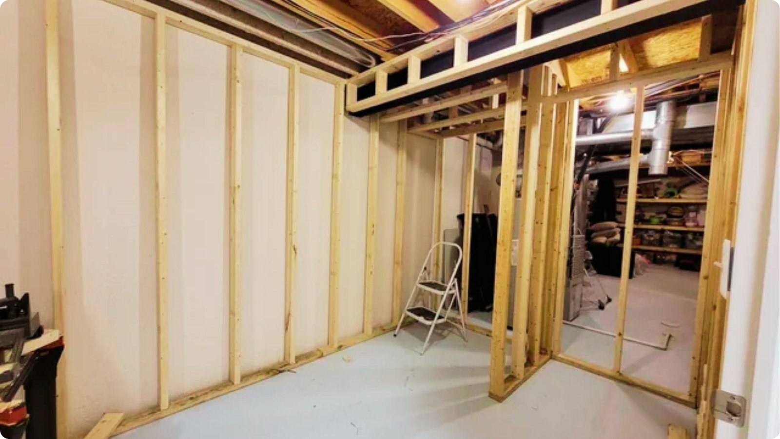 Unfinished basement bathroom framing with exposed wood studs and basic drywall.