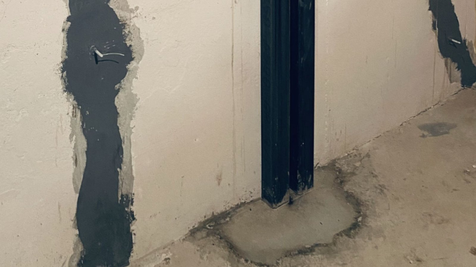 Sealed basement wall cracks with epoxy and steel brace installed to prevent further damage.
