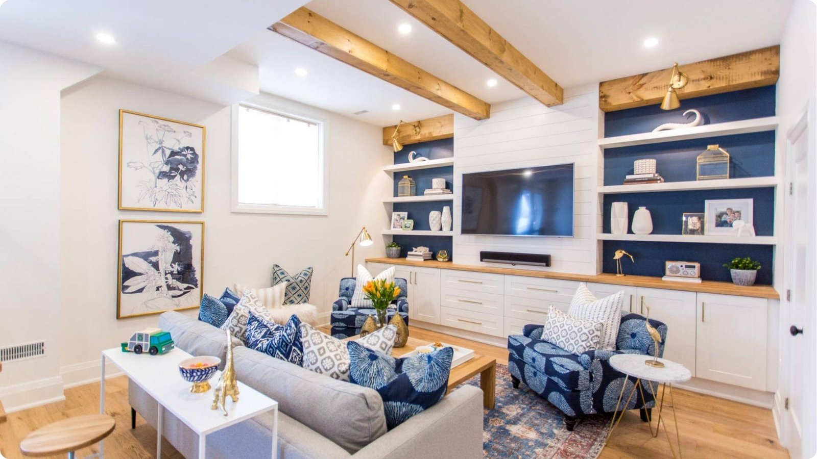Designer basement remodel with navy built-ins and wood beam ceiling details.