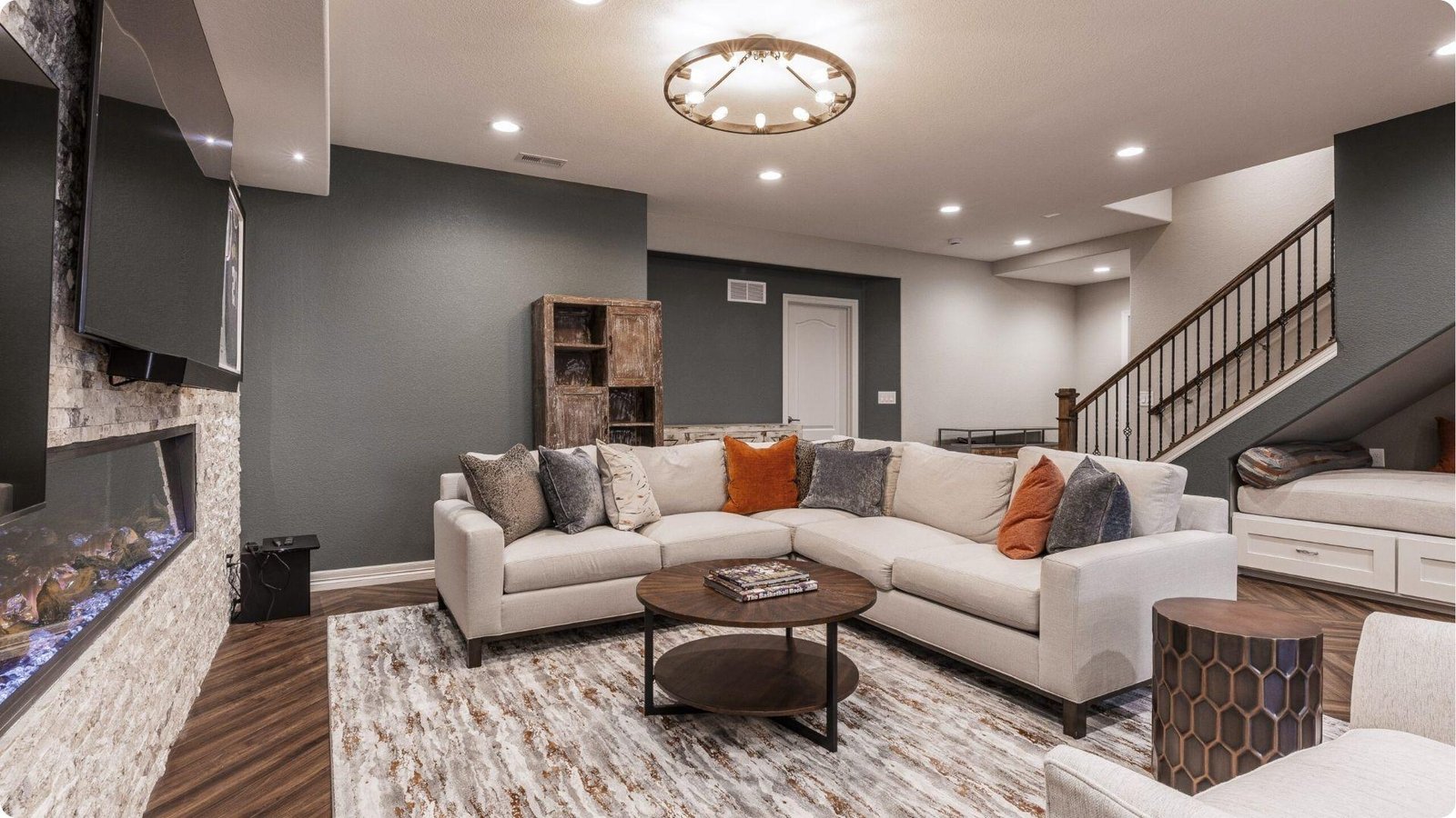 High-end basement remodel featuring a stone accent wall and linear electric fireplace.
