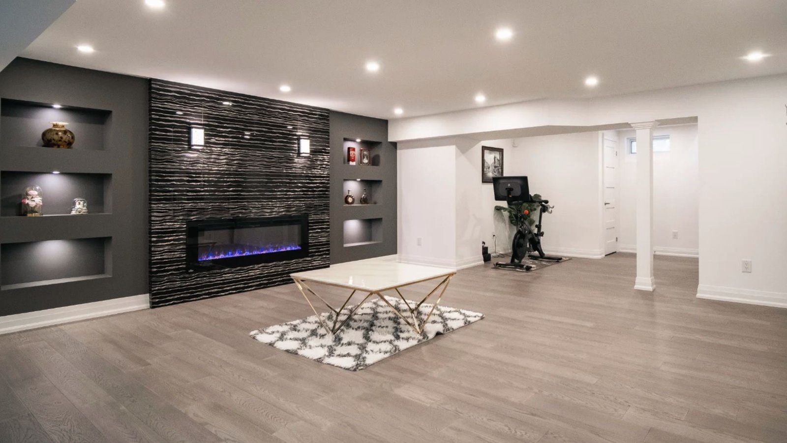 Modern fireplace with recessed shelves disguises sump pump behind vented side cabinetry.