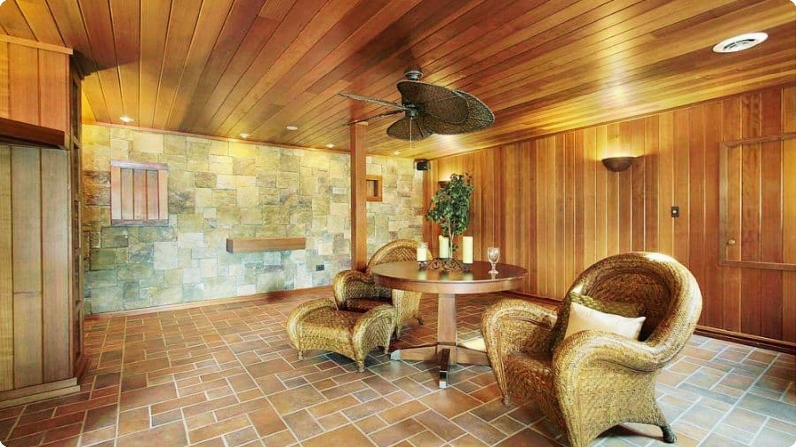 Cozy basement lounge with wood-paneled walls and ceiling that emphasize the low height.