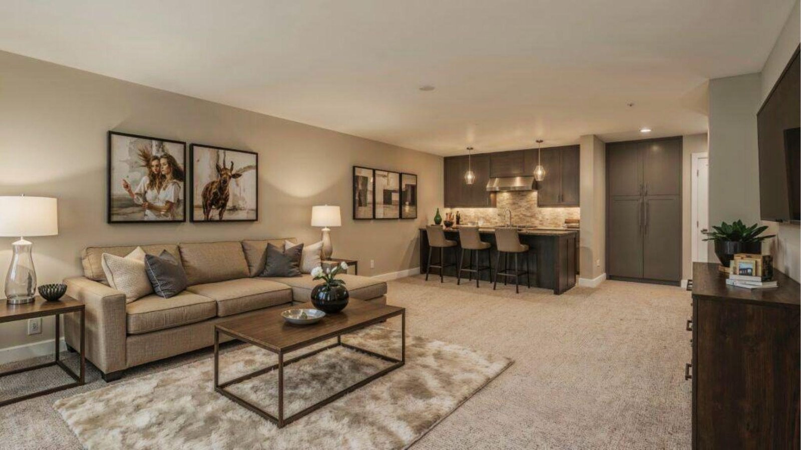 Luxury basement with sectional sofa, wet bar, and kitchenette reflecting premium basement renovation cost for entertainment spaces.
