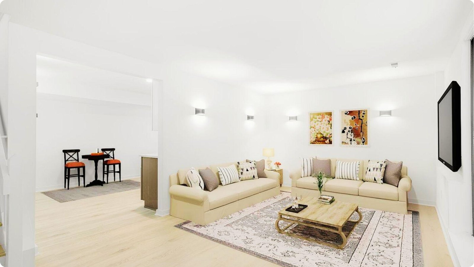 Bright, finished basement living room featuring cream sofas, wall sconces, and light wood flooring.
